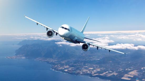 Passenger jet in flight above a coastline
